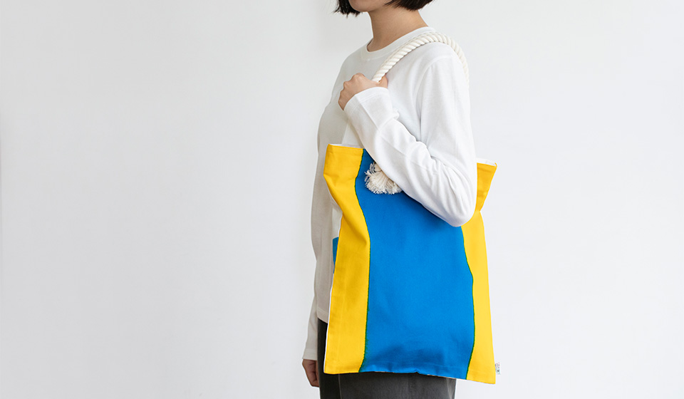 絶大なインパクトの奥に、港町の手仕事が詰まっています。加賀谷旗店の国際信号旗フラットバッグ